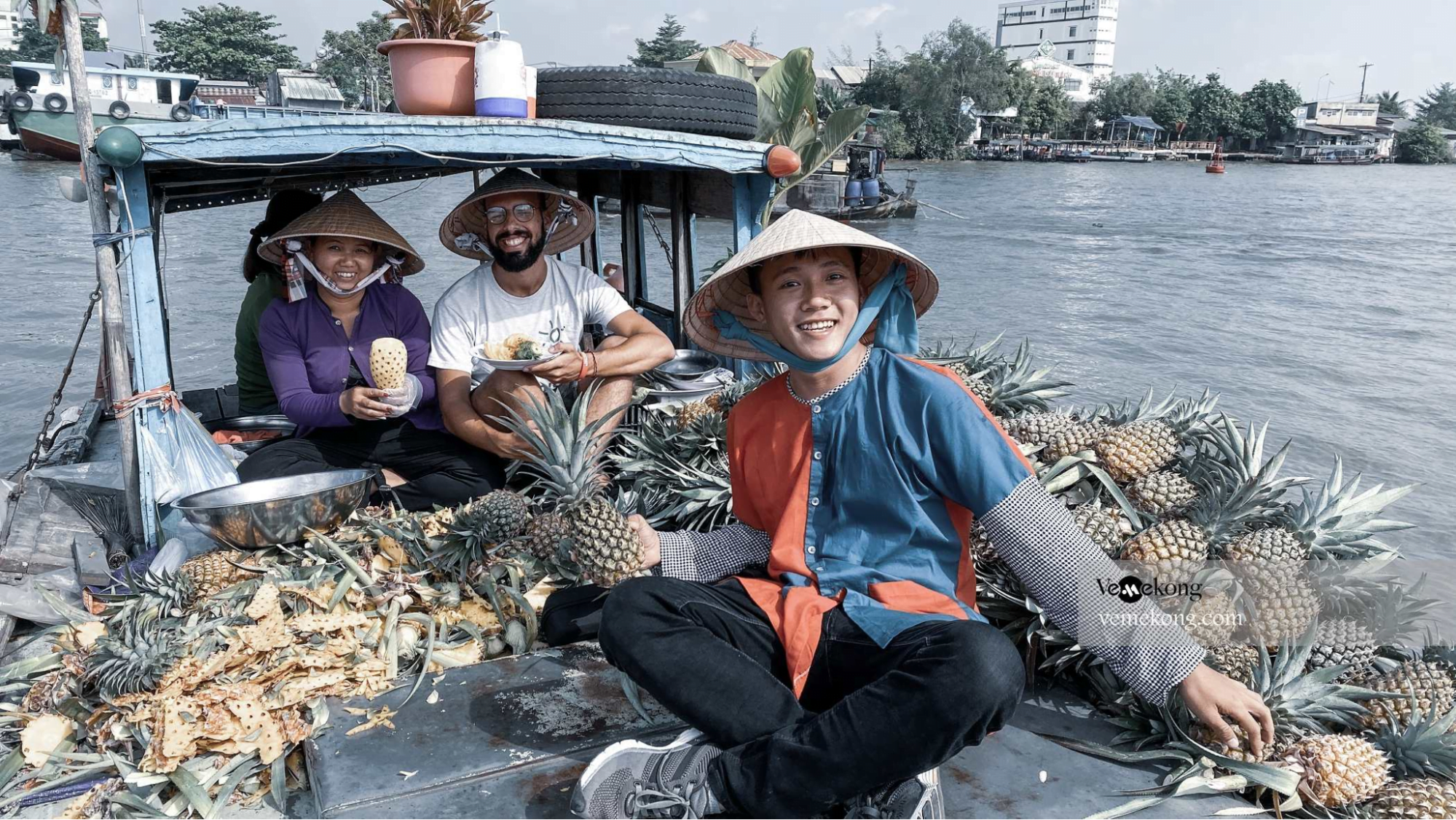 Visitors eat fruit in Cai Rang floating market